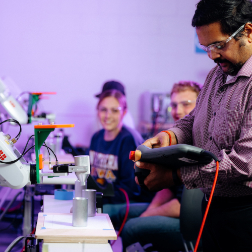 Professor working with students in a lab